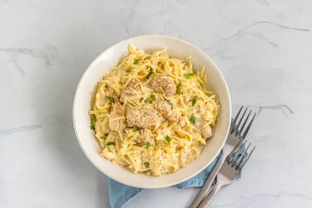 One Pot Chicken Alfredo Pasta in a White Bowl Directly from Above Photo. Creamy Chicken Pasta with Basil Leaves, Italian "nFood Photography.