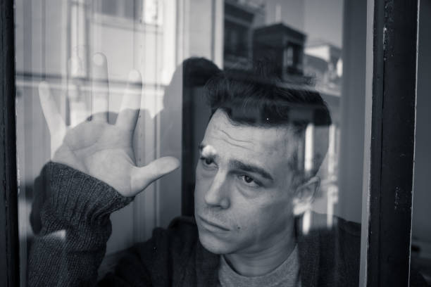 istock Sad man feeling desperate sad looking throughout the balcony worried depressed thoughtful and lonely at home in Depression Mental health Personal problems and Life style concept. 1159626094