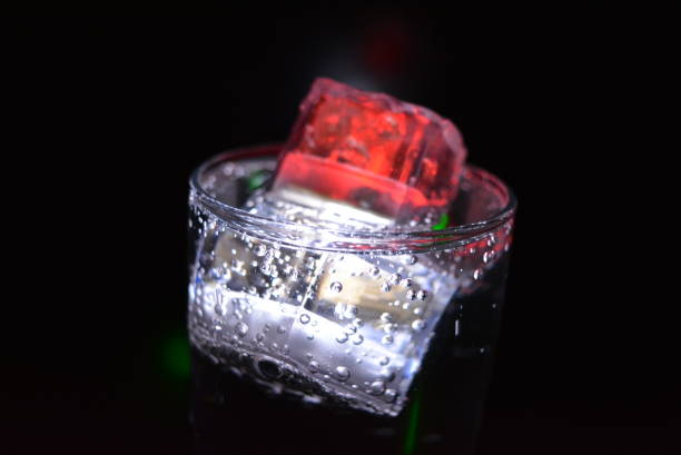Photo of Very beautiful and stunning images of drinks with glowing ice cubes.  Bright colors with bubbles in a glass of champagne.  Promotional image of a relaxing, dear life and a tasty sparkling drink.