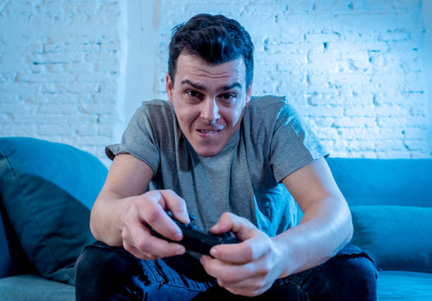 istock Portrait of young student man spending time playing video games using wireless remote joystick with freak intense happy face having fun in Male game addiction to console play station and video. 1159627121