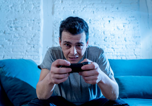 istock Portrait of young student man spending time playing video games using wireless remote joystick with freak intense happy face having fun in Male game addiction to console play station and video. 1159627200