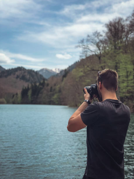 istock Man photographing lake 1159627610