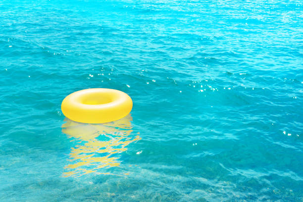 istock a yellow rubber ring floats in the crystal blue sea in summer 1159628012
