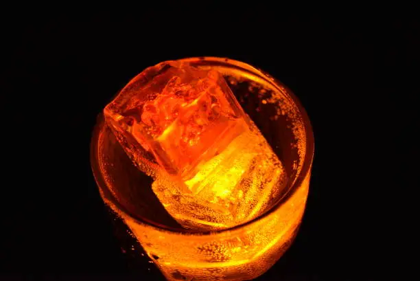 Beautiful photos of glass with carbonated drinks and diode ice cubes.  Glowing ice cubes in wine glasses, original festive background.  Bright and colorful images with light and color effects from plastic ice on batteries.