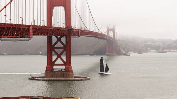 霧と大きなヨットが下を航行するゴールデンゲートブリッジ - golden gate bridge bridge large san francisco county ストックフォトと画像