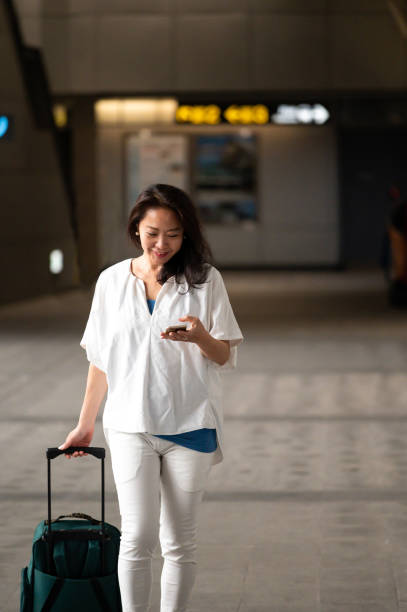 istock Businesswoman using cellphone at subway station 1159630303