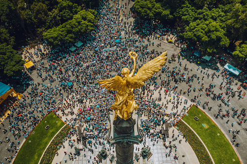 High Angle View Of Crowd Marching On Independence monument in Mexico City.