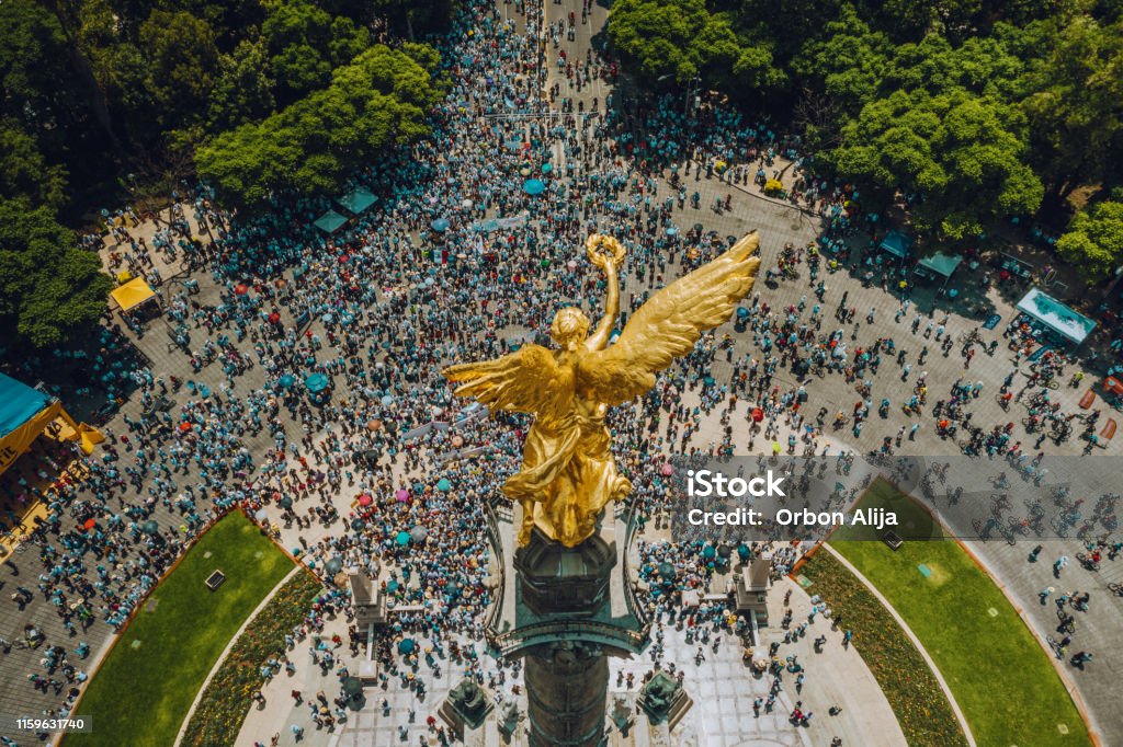 Crowd Marching in Mexico City. High Angle View Of Crowd Marching On Independence monument in Mexico City. Mexico Stock Photo