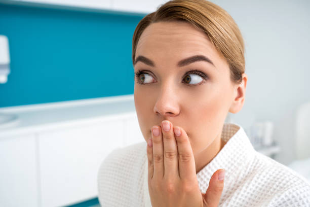 istock Scared lady looking away and closing her mouth with one hand 1159632164
