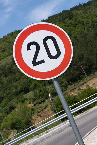 Selective focus shot of a Maximum Speed Limit 40 Street Sign with a street in the background