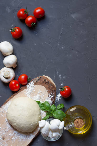 istock Pizza ingredients on the grey background with copy space, vertical photo, dough, tomatoes, mushrooms, basil, mozzarella 1159635543