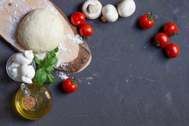 istock Raw pizza ingredients on the grey board with copy space on the center, you can put your image or inscription 1159635544