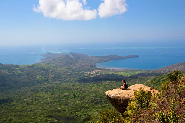 Meditation over beautiful landscape of Mayotte island Choungui (Mayotte island) - September 20 2014: Wonderful landscape on the top of Mayotte Island, Mount Choungui, with someone meditating alone on a flat rock mayotte stock pictures, royalty-free photos & images