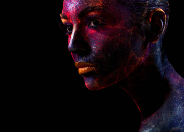 istock Crop sensual woman with colored face in dark 1159640412