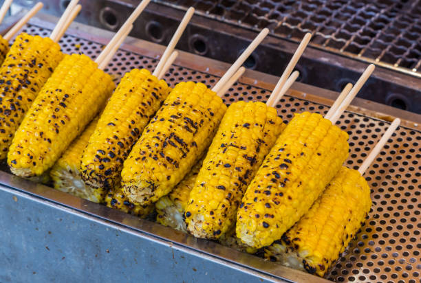 istock grilled butter corn with stick on grill table. 1159640515