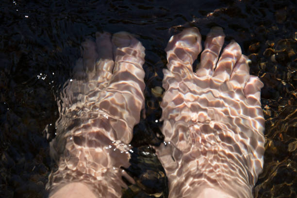 Looking down at two feet beneath the water in a shallow river.http://i879.photobucket.com/albums/ab359/mikespics1/Healthy%20Living/HealthyLivingBanner.jpg