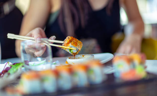 istock A woman in a restaurant dines sushi 1159642036