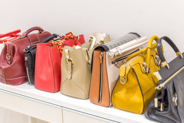 istock Collection of handbags standing in a row 1159642813