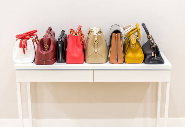 istock Collection of handbags standing in a row 1159642945