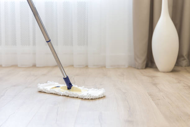 istock Cleaning floor with white mop near sofa 1159643075
