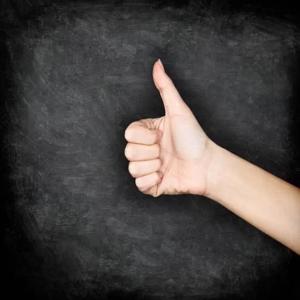 Photo of Like - Likes hand giving thumbs up on blackboard