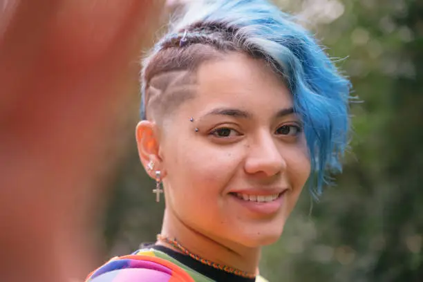 Young cheerful woman with beautiful smile and blue short hair.