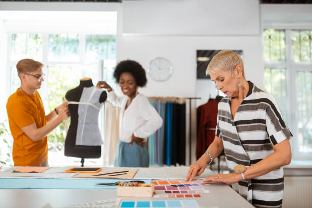 istock Senior female designer standing beside the cutting table 1159644657
