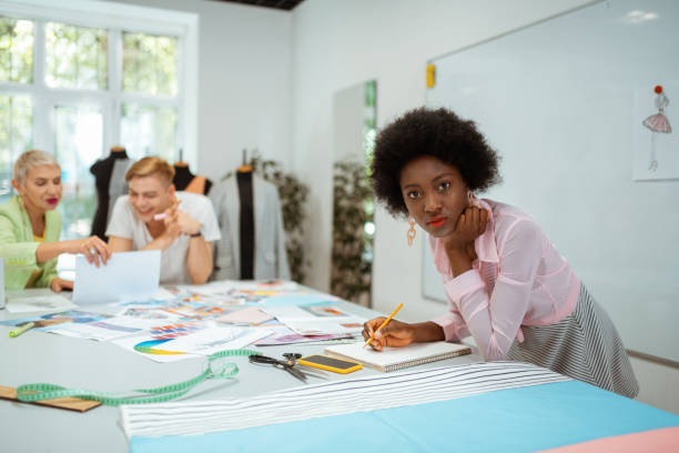 istock Pretty woman designer leaning on a cutting table 1159644756