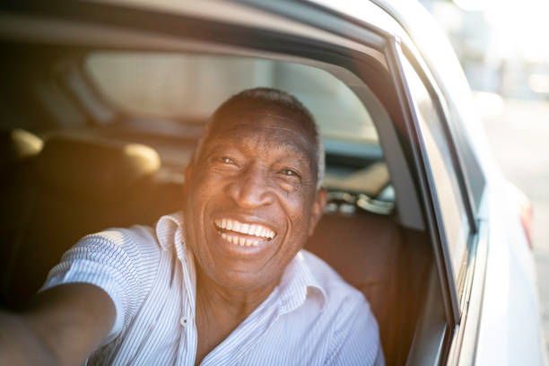 istock Smiling senior man taking a selfie in a car 1159645513