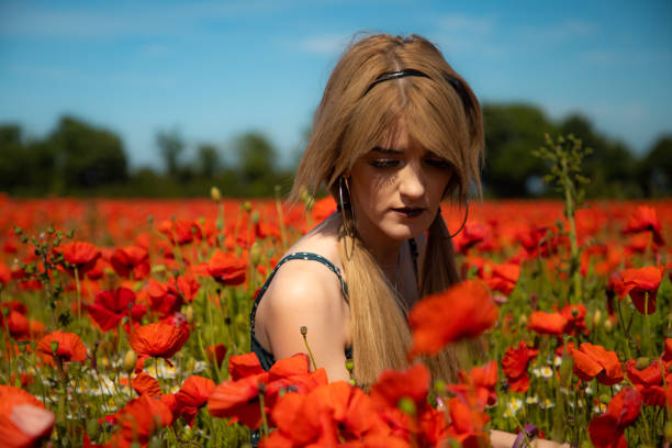 istock A young lady in a poppy field 1159646866