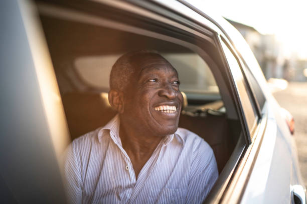 uśmiechnięty starszy pasażer samochodu patrząc przez okno - car old black white zdjęcia i obrazy z banku zdjęć