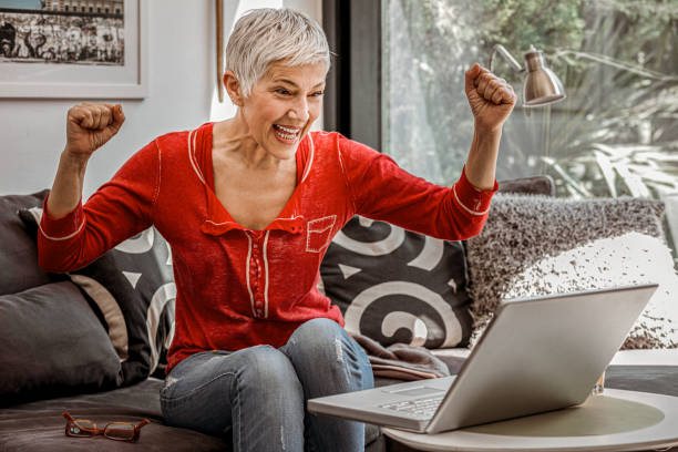 istock Mature woman using laptop at home 1159648588