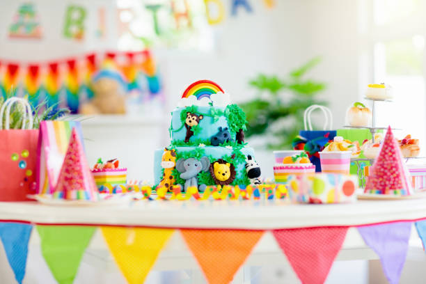 Kids birthday cake. Child jungle theme party. Cake for kids birthday celebration. Jungle animals theme children party. Decorated room for boy or girl kid birthday. Table setting with presents, gift boxes, confetti and sweets. Pastry for child party theme and decoration stock pictures, royalty-free photos & images