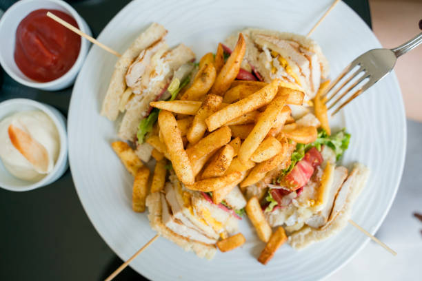French fries chips with club sandwich on plate, directly above French fries chips with club sandwich on plate, directly above sandwich club sandwich lunch restaurant stock pictures, royalty-free photos & images