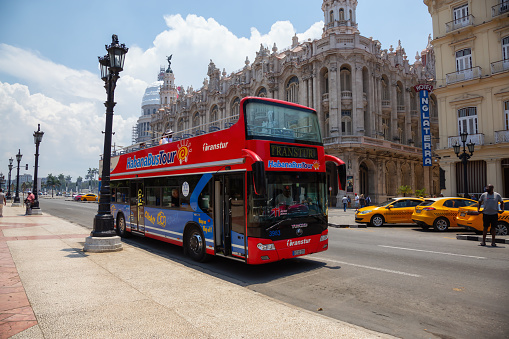 Havana, Cuba - May 19, 2019: Touristic Bus Tour, Hop on Hop Off, in the streets of the Old Havana City during a vibrant and bright sunny day.