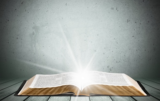 Open book on old wooden table.