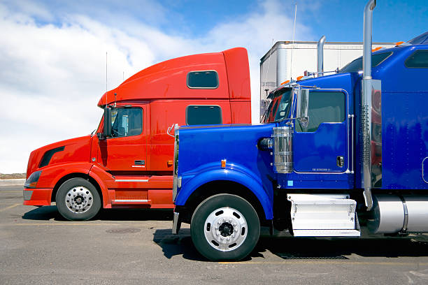 istock One red semi truck trailer parked next to a blue one 115966089