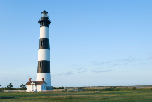 Bodie Island lighthouse is a landmark in the Outer Banks with black and white stripes sitting high above the level seacoast terrain, near Nags Head, North Carolina, NC, USA, 