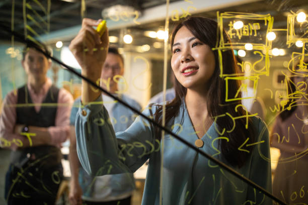 istock Businesswoman sharing ideas on glass wall 1159663980