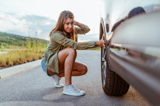 This is going to ruin my trip! Casual brown hair women in the city with a flat tire frustrated. flat tire stock pictures, royalty-free photos & images