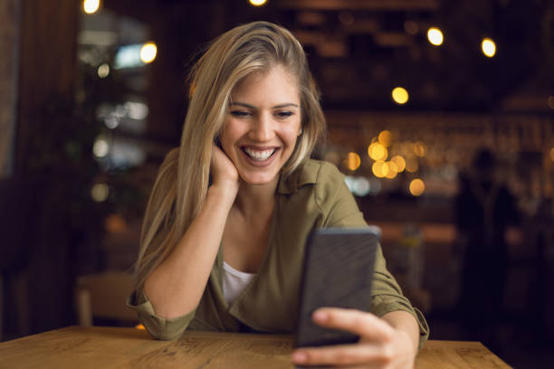 istock Young woman text messaging on mobile phone in a cafe 1159666318