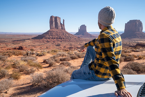 Road trip concept; Young man outside RV looking at landscape ; national parks and nature ready for adventure