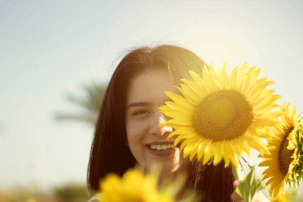istock Beautiful young girl in sunflower field 1159667708