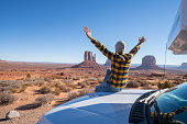 Young man with rental motor home enjoying road trip in USA