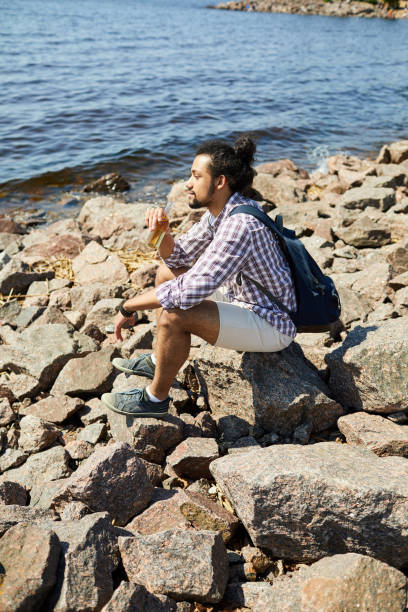 istock Pensive Young Man by Sea 1159669286