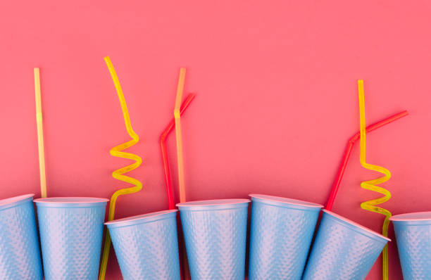 istock Plastic blue cups and tubules on a pink background 1159671283