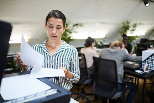 Business Secretary Scanning Documents Waist up portrait of young businesswoman scanning documents while working in office, copy space scanning activity photos stock pictures, royalty-free photos & images