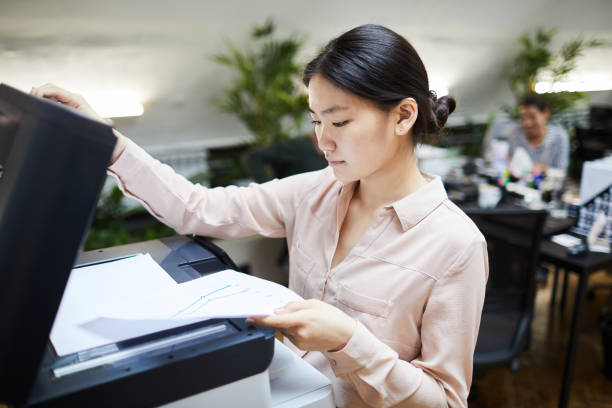 istock Asian Businesswoman Printing Documents in Office 1159673571