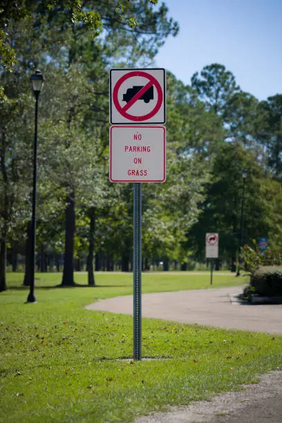 Photo of Traffic sign prohibiting the parking on the grass in the park. Nature. Road sign in the rest area. Rules for travelers.