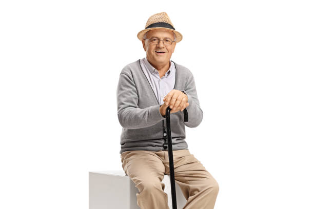 istock Elderly man with a cane sitting and looking at the camera 1159678449